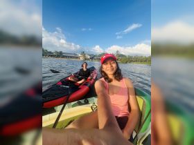 Two young girls enjoy a fun kayaking adventure on calm waters, showcasing smiles and a perfect day for water activities.