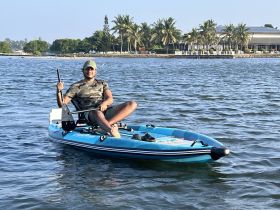 A young man enjoys kayaking on calm waters, showcasing the perfect blend of adventure and relaxation in a scenic setting.
