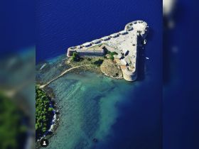 A stunning aerial view of a historic fortress surrounded by clear blue waters, showcasing the beauty of coastal landmarks perfect for exploration.