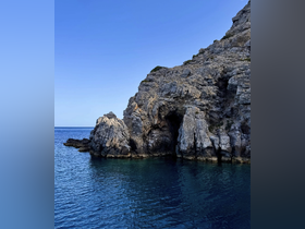 A stunning view of rocky cliffs meeting the tranquil sea, showcasing the natural beauty of the coastline — perfect for scenic boat tours and exploration.