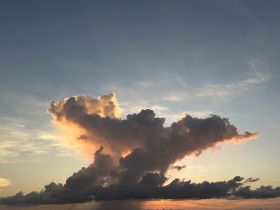 A captivating view of clouds illuminated by sunset hues, creating a dramatic sky scene.