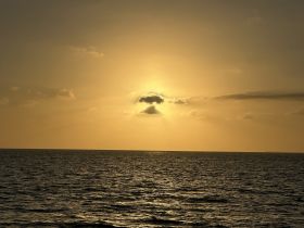 A serene sunset over the ocean, creating a picturesque backdrop perfect for evening boat cruises.