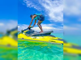 A thrilling moment captured as a person rides a jet ski over crystal-clear waters, showcasing the excitement of water sports and adventure on the open sea.