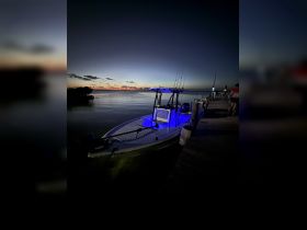 A sleek speedboat illuminated with blue lights, docked at sunset, showcasing the perfect setting for evening adventures on the water.