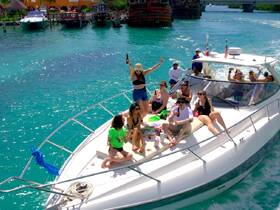 A lively group enjoys a fun day on the water, celebrating with drinks aboard a sleek boat, surrounded by stunning turquoise waters — perfect for unforgettable outings.