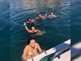 A lively group enjoys a refreshing swim in clear waters, showcasing the joy of summer adventures on the water.