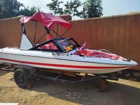 A sleek speedboat displayed on a trailer, showcasing its vibrant design and ready for adventure on the water.