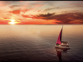 A stunning aerial view of a sailboat gliding through calm waters at sunset, showcasing the beauty of sailing adventures.