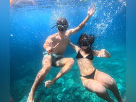 A couple enjoys an exhilarating snorkeling adventure underwater, showcasing the vibrant marine life and crystal-clear waters — a perfect moment for aquatic exploration.