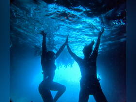 A vibrant underwater scene captures a group of friends joyfully celebrating while swimming, showcasing the fun and excitement of aquatic adventures.