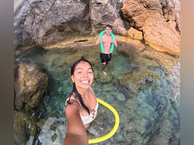 A joyful moment captured as two friends enjoy swimming in crystal-clear waters, showcasing the fun of a tropical adventure.