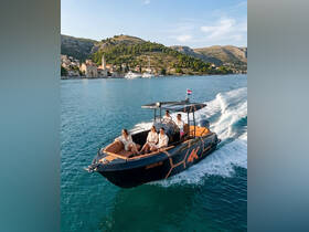 A lively group enjoys a scenic boat ride through clear waters, showcasing the beauty of the coastline and the joy of on-water adventures.