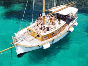 A lively group of friends enjoys a sun-soaked day aboard a beautiful yacht, perfect for celebrations and memorable outings on the water.