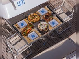 A beautifully arranged dining table on a boat featuring a variety of delicious dishes, perfect for enjoying meals while cruising on the water.