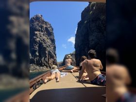 A group of friends enjoys a scenic boat ride through rocky formations, capturing the essence of adventure and exploration on the water.