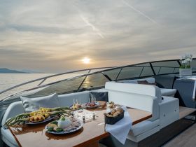 An elegant dining setup on a yacht featuring a variety of delicious food and drinks, perfect for enjoying a sunset cruise on the water.