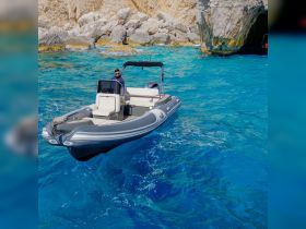 A sleek speedboat navigates through crystal-clear turquoise waters, showcasing its stylish design and perfect for thrilling adventures on the sea.
