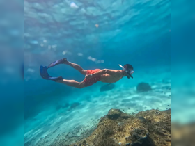 A young snorkeler explores the vibrant underwater world, showcasing the beauty of marine life in crystal-clear waters — a perfect adventure for ocean enthusiasts.