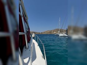 A side view of a boat cruising through clear waters, showcasing the beautiful coastal landscape in the background — perfect for exploring scenic destinations.