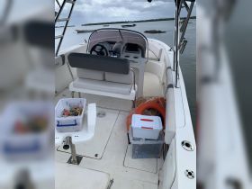 Interior view of a boat's helm area, showcasing the seating and console, ideal for navigation and comfort while on the water.