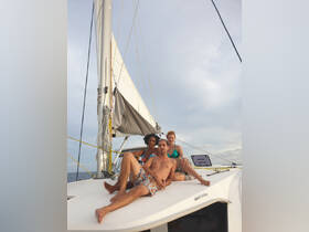 A group of friends relaxes on the deck of a sailboat, enjoying the sun and sea — perfect for memorable sailing adventures.