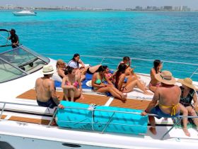 A lively group enjoys a sunny day on a yacht, lounging and soaking up the sun on turquoise waters — perfect for a fun day out at sea.
