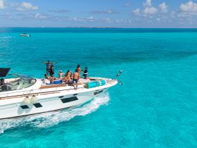 A lively group enjoys a day on a yacht in stunning turquoise waters, celebrating and soaking up the sun — the perfect backdrop for unforgettable summer adventures.