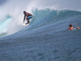 A thrilling moment captured as a surfer rides a wave, showcasing the excitement of water sports in the ocean.