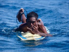A young boy enjoys surfing in the ocean, showcasing the thrill of water sports and the beauty of the sea.