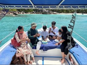 A joyful family celebrates a birthday on a boat, surrounded by stunning turquoise waters — a perfect setting for memorable moments and family gatherings.
