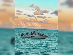 A lively group enjoys a boat ride during sunset, creating a perfect backdrop for memorable celebrations on the water.