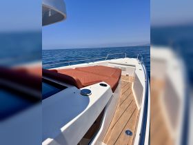 A sleek speedboat glides through calm waters, showcasing its elegant design and spacious deck — perfect for a day of adventure on the sea.