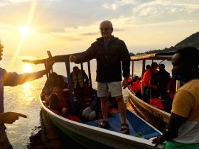 A lively scene at sunset with a group of people interacting on a boat, capturing the essence of adventure and camaraderie on the water.