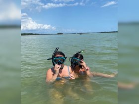 Two young girls enjoy snorkeling in clear waters, showcasing a fun and adventurous day on the water.