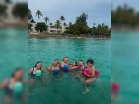 A joyful group of friends enjoys a fun day swimming in the turquoise waters, perfect for creating unforgettable beach memories.