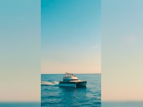 A stylish yacht cruises through the sparkling waters, showcasing a perfect day on the sea with guests enjoying the ride.