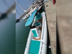 A sleek speedboat docked at the marina, showcasing its stylish design and inviting seating area — perfect for a day out on the water.