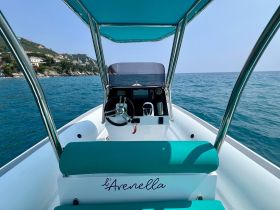 A clean and modern helm view of the boat 'l'Avenella', showcasing the console and seating area, perfect for navigating the beautiful waters.