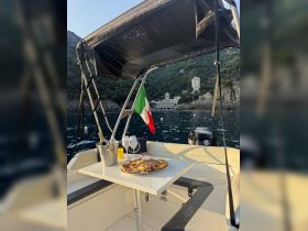 A beautifully set dining area on a boat featuring a platter of delicious food and drinks, perfect for a relaxing day on the water.