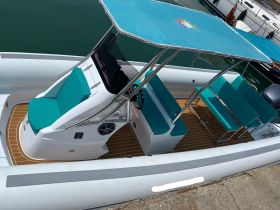 Interior view of a stylish boat featuring comfortable seating and a helm, perfect for enjoying a day on the water.