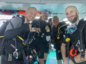 A group of divers prepares for an underwater adventure, showcasing the excitement of scuba diving in a vibrant marine environment.