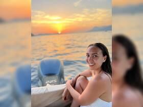 A woman enjoys a stunning sunset on the water, creating a perfect backdrop for memorable boat trips and romantic evenings.