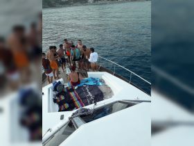 A lively group enjoys drinks and camaraderie on the deck of a boat, perfect for celebrations and social gatherings on the water.