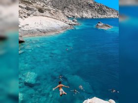 A thrilling moment captured as a group enjoys cliff diving into crystal-clear waters, showcasing the excitement of summer adventures and water activities.