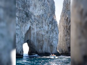 Two boats navigate through a stunning rock formation at Cabo San Lucas, showcasing the breathtaking coastal scenery — a must-see landmark for visitors.