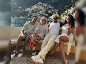 A cheerful group of friends enjoys a scenic moment aboard a boat, with the picturesque coastline of Positano in the background — perfect for memorable gatherings on the water.