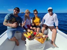 A cheerful group enjoys a delicious spread of snacks on a boat, capturing the essence of a fun day out on the water.