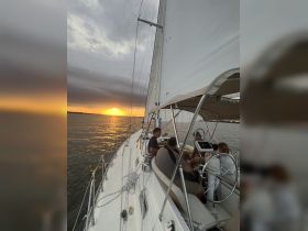 A group enjoys a sunset sailing experience, capturing the beauty of the evening while navigating the waters together.