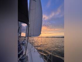 A stunning view of a sailboat gliding through tranquil waters at sunset, showcasing the beauty of sailing and the serene atmosphere of the open sea.