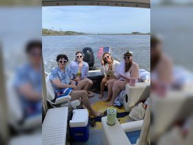 A lively group of friends enjoys a fun day on the boat, showcasing a perfect blend of relaxation and celebration on the water.